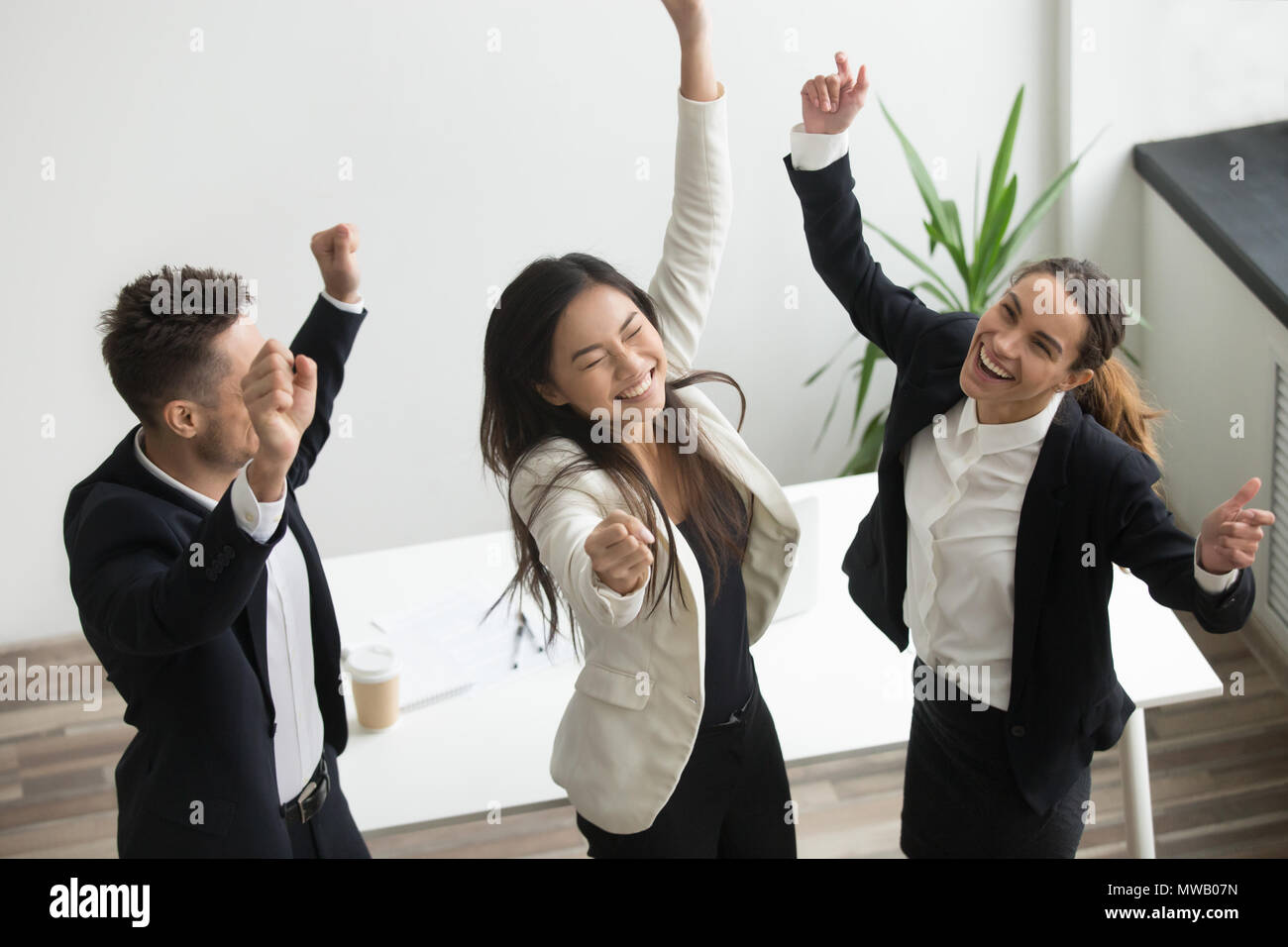 Victory dance concept, excited diverse coworkers celebrating bus Stock Photo