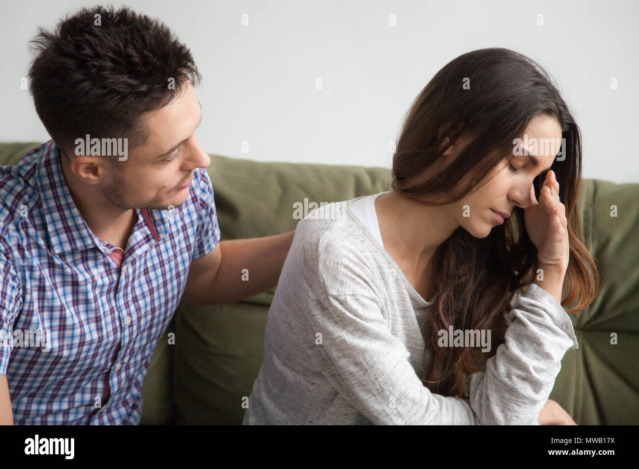 Caring husband apologizing crying upset wife excusing for being  Stock Photo