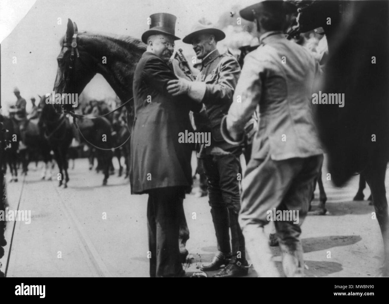 . English: Photograph showing Theodore Roosevelt and Col. Alexander O. Brodie, in uniform, greeting each other, surrounded by horses. circa 1910 June 23. Paul Thompson (photographer) 253 Greeting Col. Brodie of Rough Riders Stock Photo