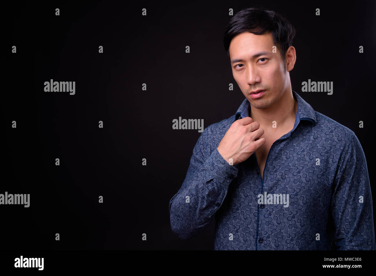 Young handsome Asian businessman against black background Stock Photo