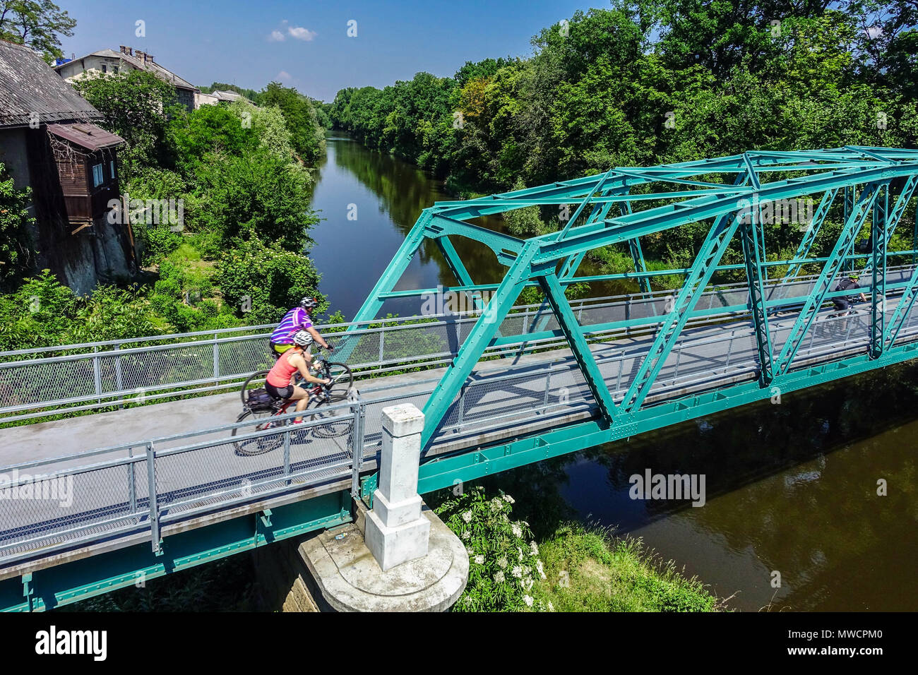 Pedestrian bridge across the Elbe Canal River at Kolin, Czech Republic People crossing the bridge of the old branch of the river Stock Photo