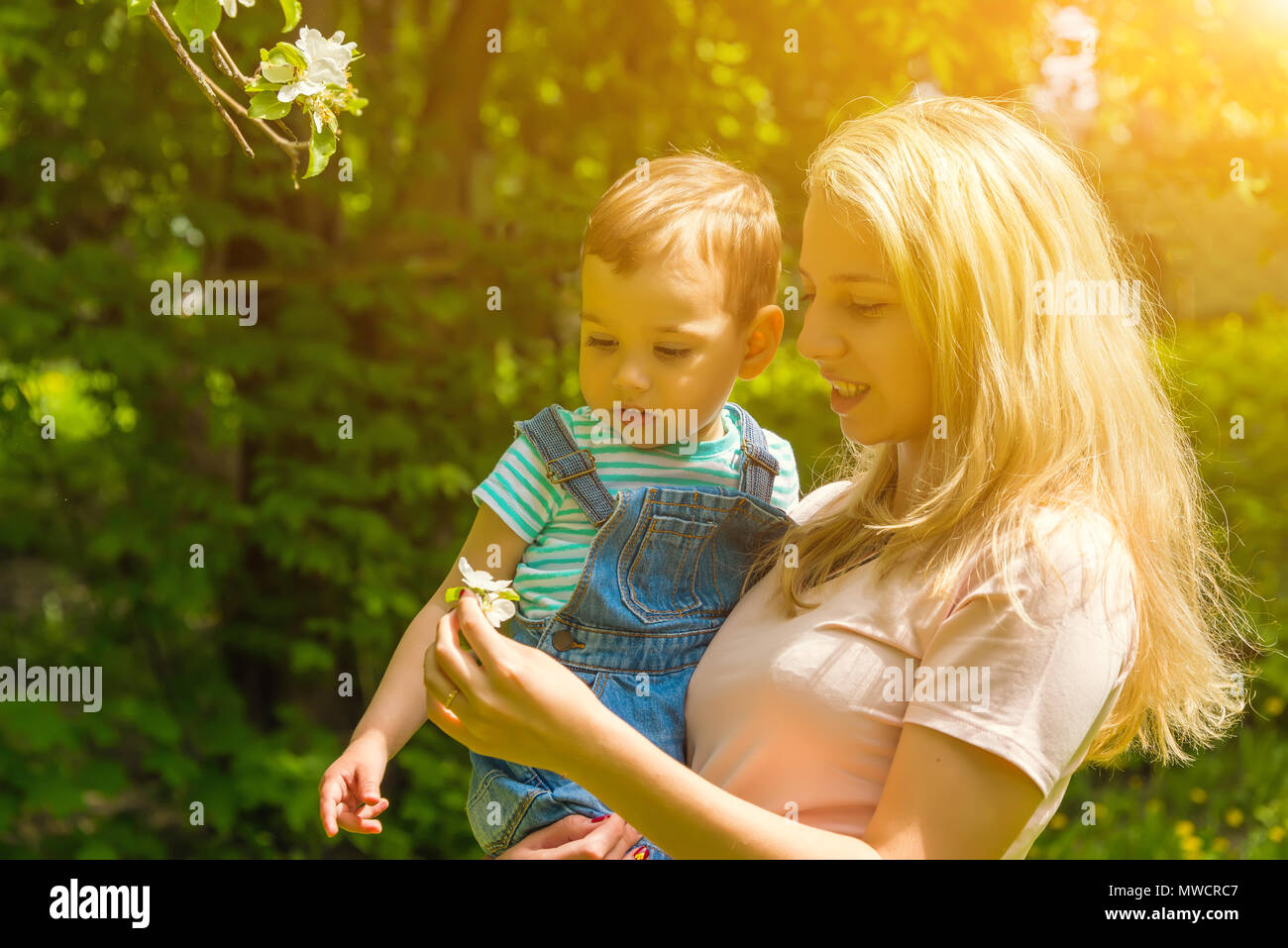 mother and child in nature in the Park, resting on the green grass in ...