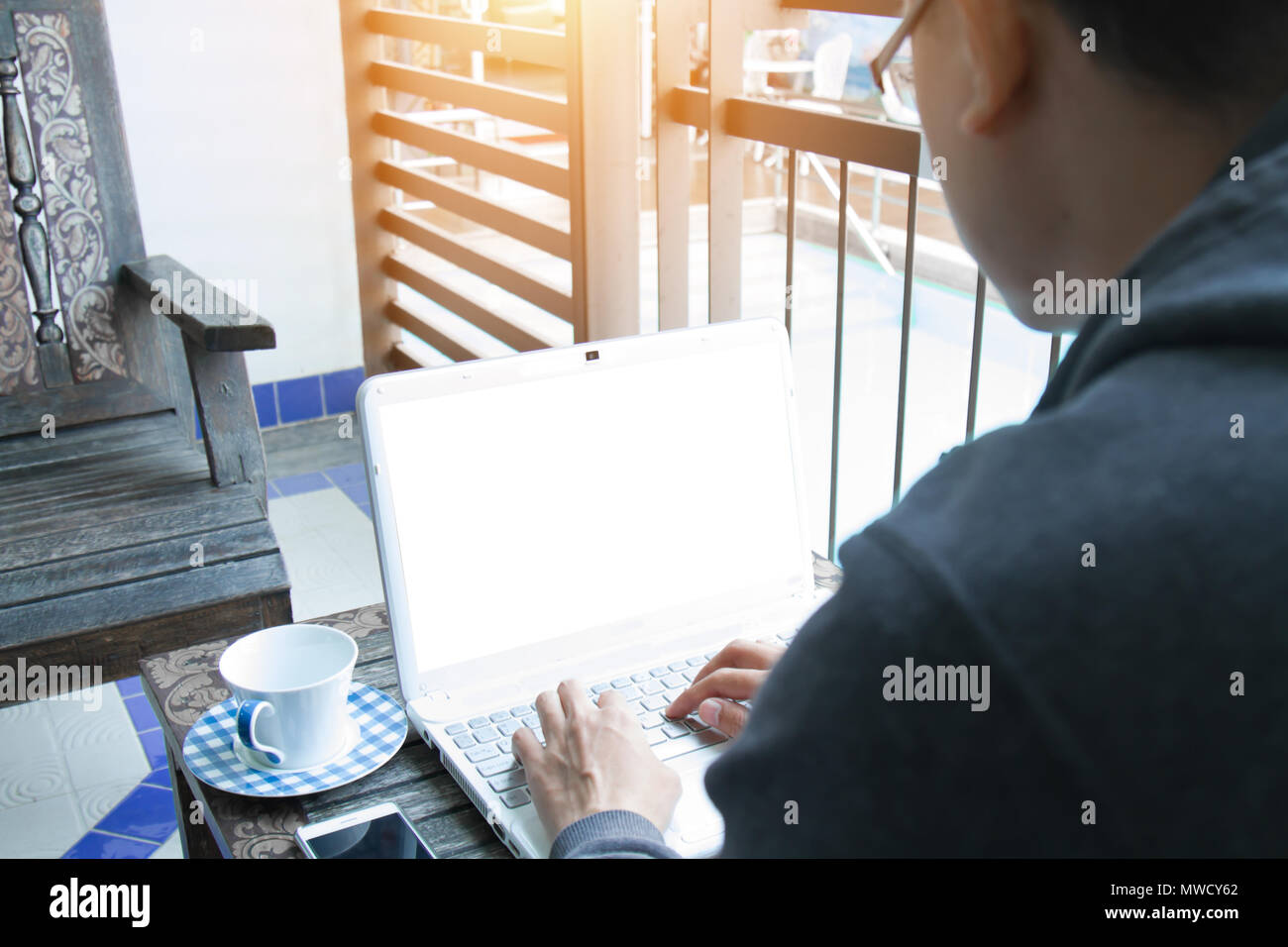 Businessman typing on keyboard laptop working with smart phone and coffee cup. The blank screen with copy space for your text or advertising content.  Stock Photo