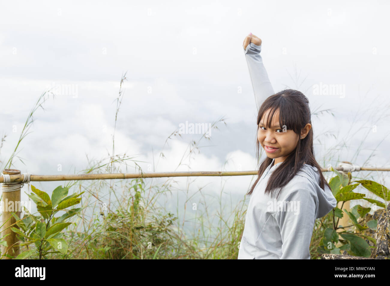 Asia girl relax and refresh on mountain background is a landscape of high mountains, white clouds and fog. Stock Photo