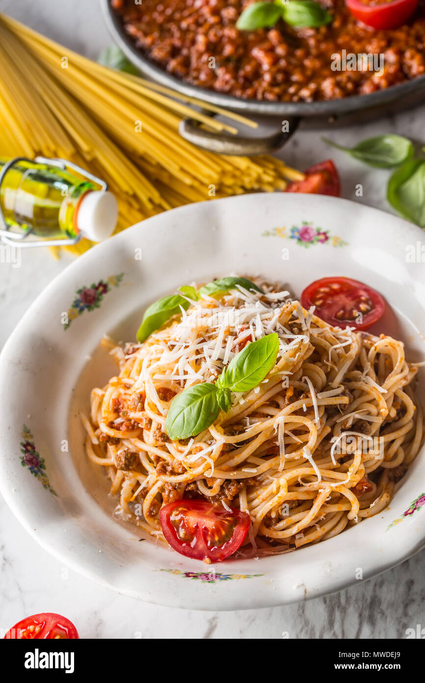 Spaghetti bolognese with ingredients basil tomatoesparmesan cheese and