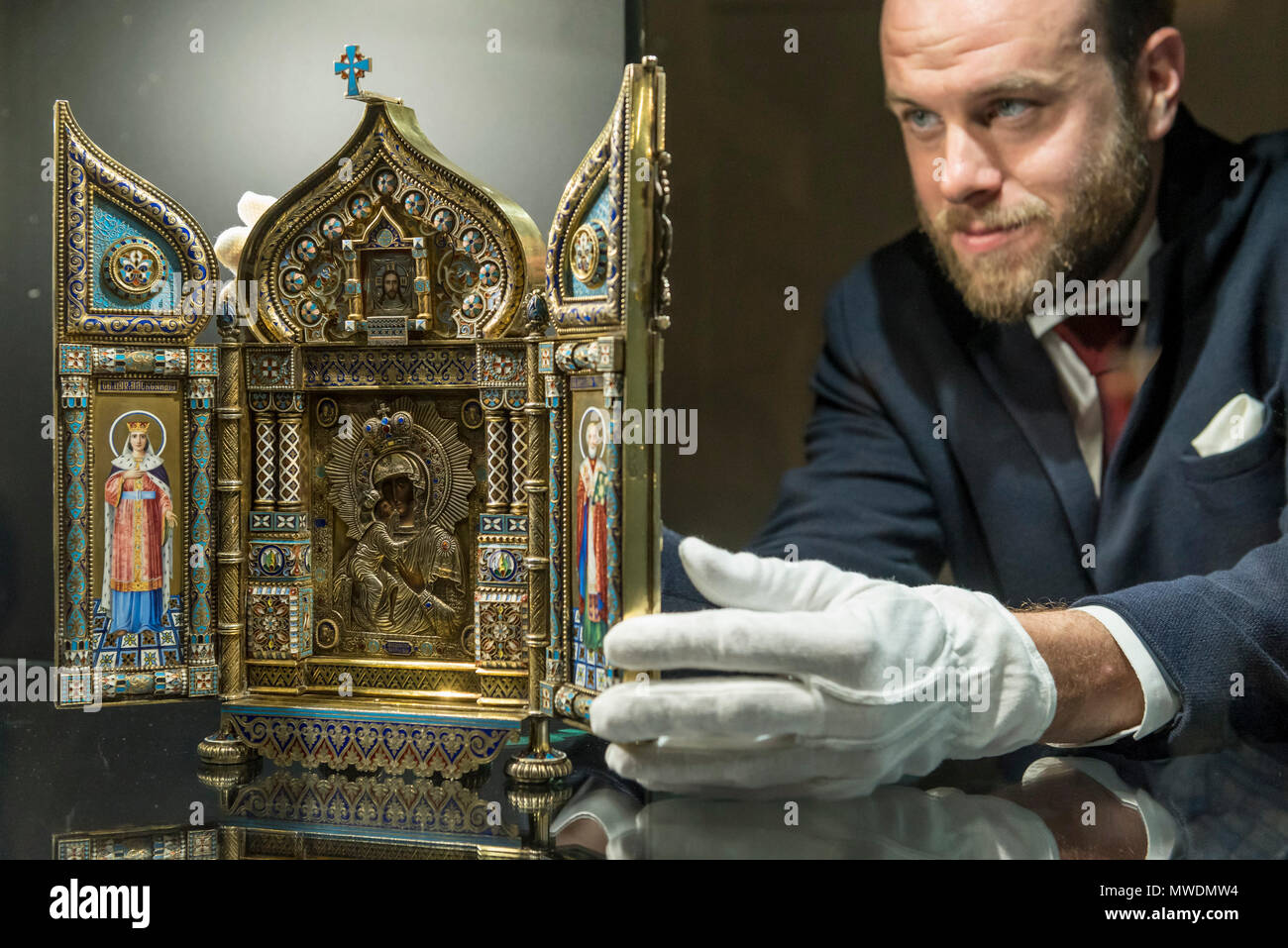 London, UK.  1 June 2018. A Sotheby's technician presents 'An Imperial Silver-Gilt and Enamel Triptych Icon of the Feodorovskaya Mother of God', 1894, by Savelev Brothers (Est. GBP80-120k) at a preview of the Russian Pictures and Russian Works of Art, Fabergé & Icons sale which will take place at Sotheby's, New Bond Street on 5 June.  Credit: Stephen Chung / Alamy Live News Stock Photo