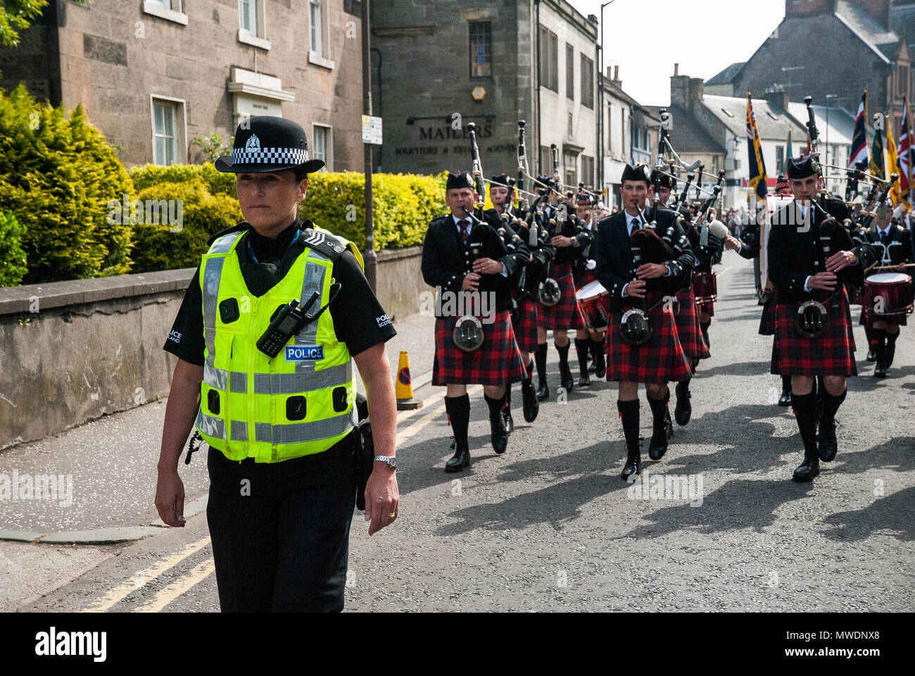 Alloa, Scotland, UK. 1st Jun, 2018. A police-woman provides an escort with members of Dollar Academy leading the parade through Alloa marking Alloa's Armed Forces Day 2018. Alloa shows its support of the UK Armed Forces as part of the UK Armed Forces Day events, this year also marks the 100th anniversary of the end of WW1 and the 100th year of the British Royal Air Force. Credit: SOPA Images Limited/Alamy Live News Stock Photo