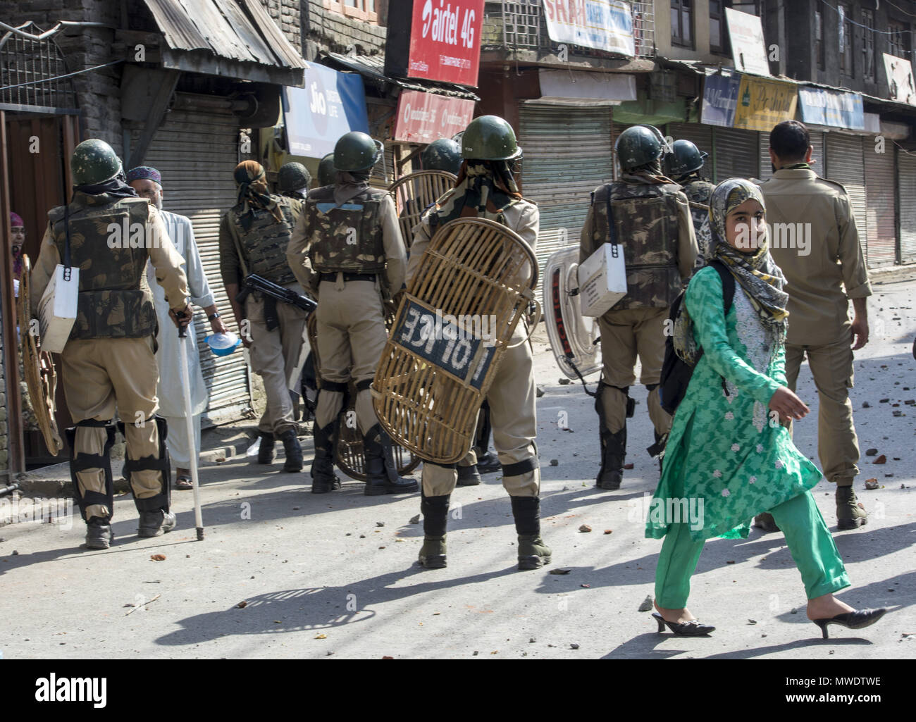 Srinagar, Jammu And Kashmir, India. 1st June, 2018. Kashmiri Muslim young girl walks past as Indian government force stands alert in Sinagar.Hundreds of people held peaceful protest soon after the congregational prayers at the Jamia Masjid (Grand mosque), in Srinagar. Heavy clashes broke out when the speedy central reserve paramilitary force's (CRPF) vehicle allegedly hit two youths during protest in Srinagar. Credit: Masrat Zahra/SOPA Images/ZUMA Wire/Alamy Live News Stock Photo