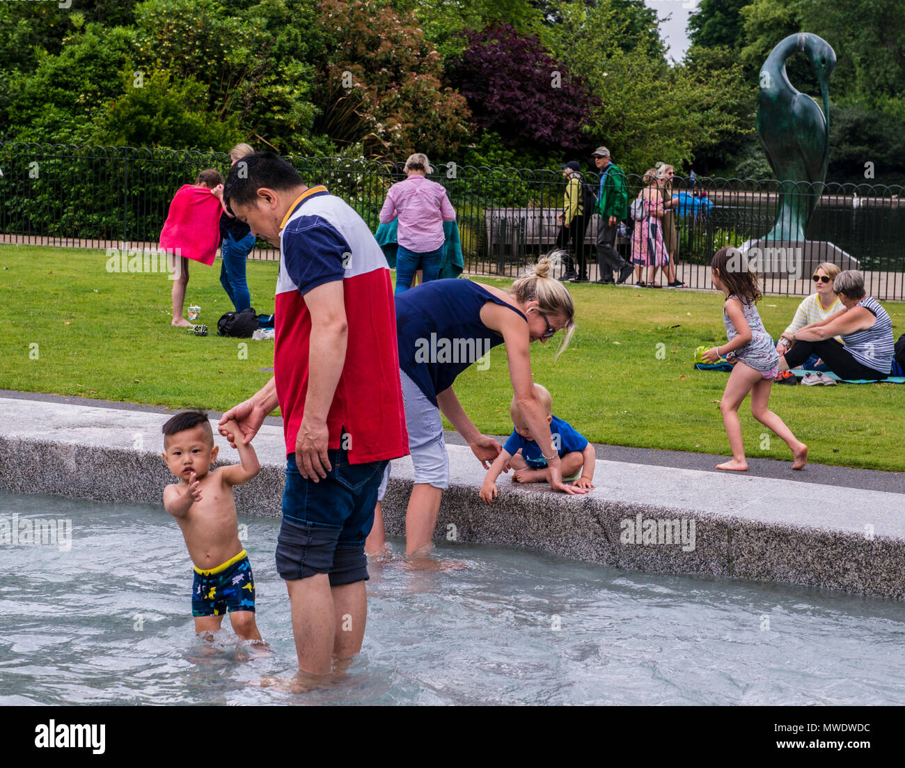 London, UK. 1st Jun, 2018. UK Weather: Cloudy day at Serpentine lake, Hyde Park.  A small boy points at the camera while playing in the water with his dad at the Princess Diana Memorial in Hyde Park. Credit: Ernesto Rogata/Alamy Live News. Stock Photo
