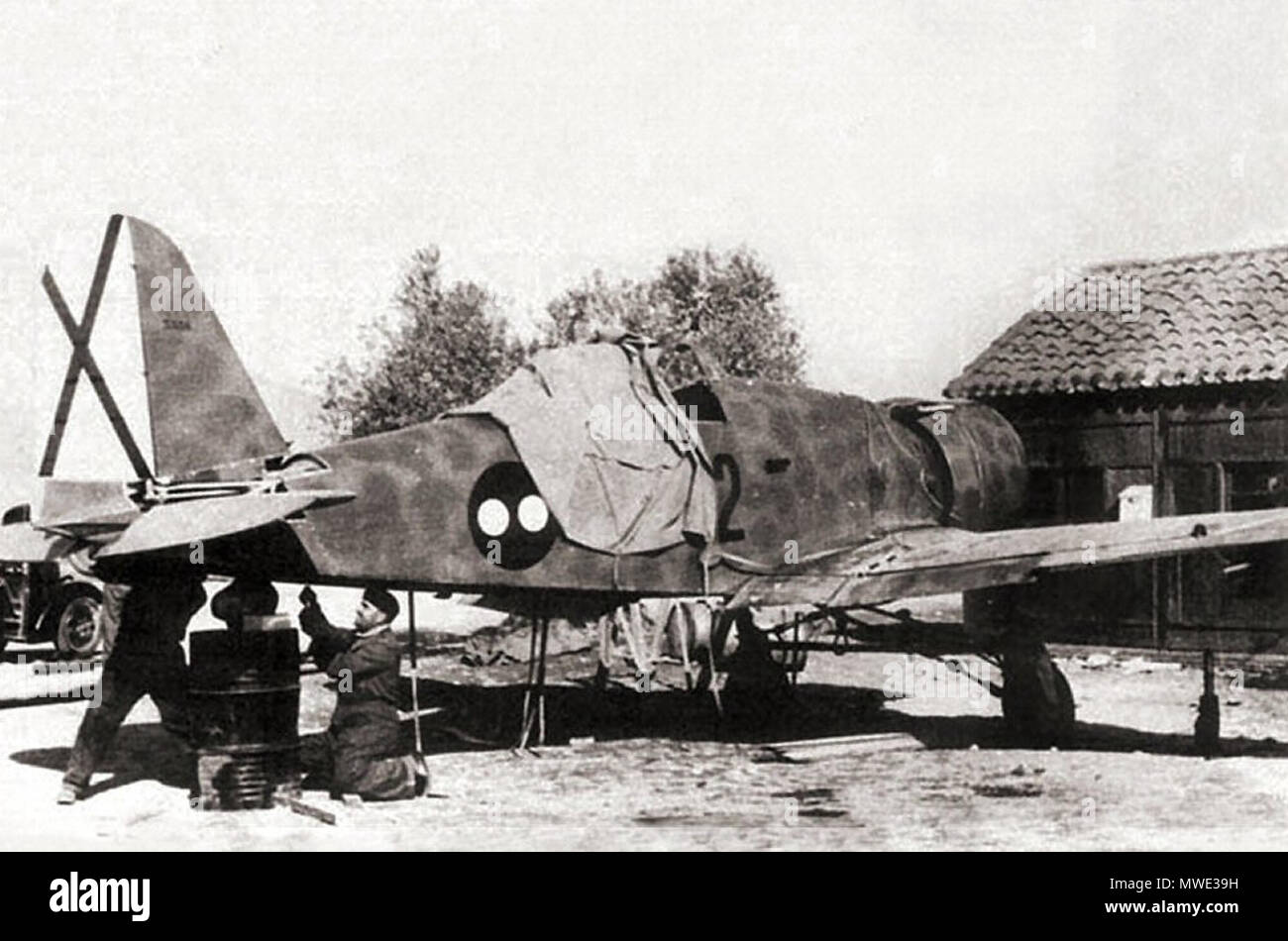 . English: Some mechanics verifying the tail ailerons of the the personal Fiat G.50 '1-2' of Capitain Roveda. 1938. Unknown 207 Fiat G.50 -Capitain Roveda. Stock Photo