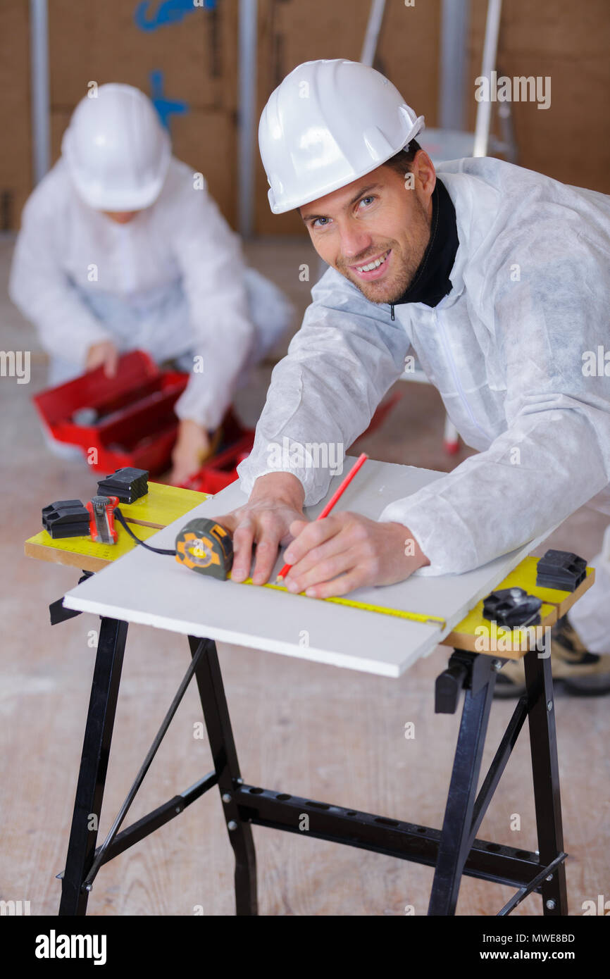 Builders Using Measure happy handsome builder using a measure tape Stock Photo - Alamy