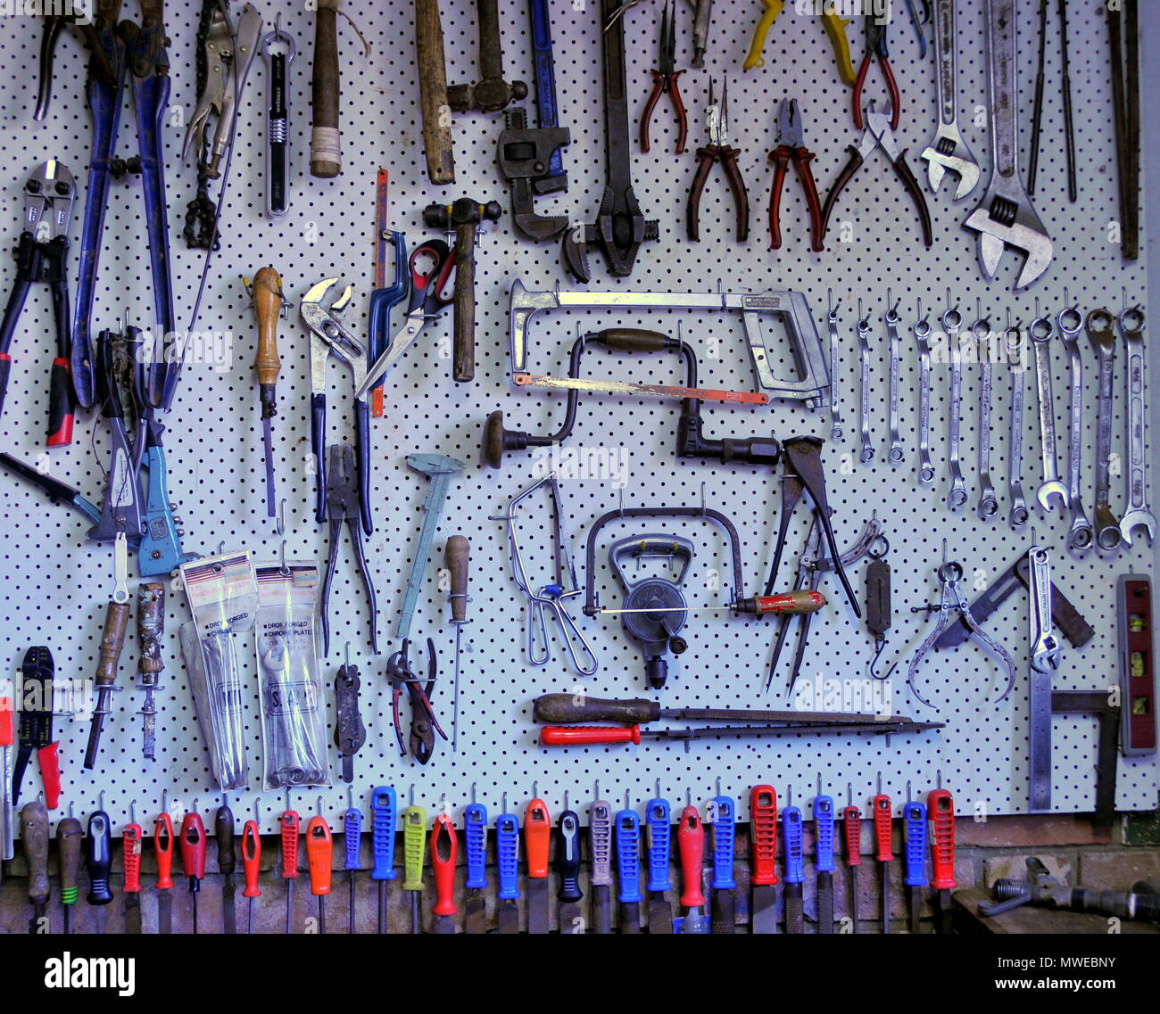 Hand tools organised for easy access on a peg board Stock Photo