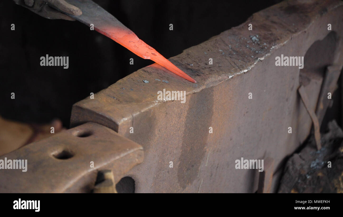 Blacksmith working metal with hammer on the anvil in the forge. hammer ...