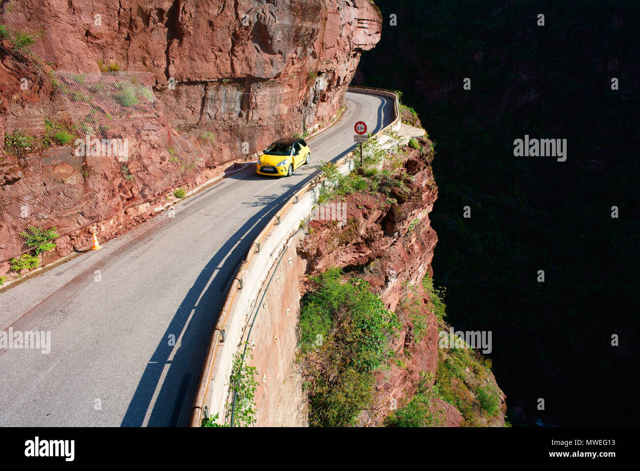 AERIAL VIEW from a 6-meter mast. Sports car on a narrow road inside a deep canyon. Gorges du Cians, French Riviera's hinterland, France. Stock Photo