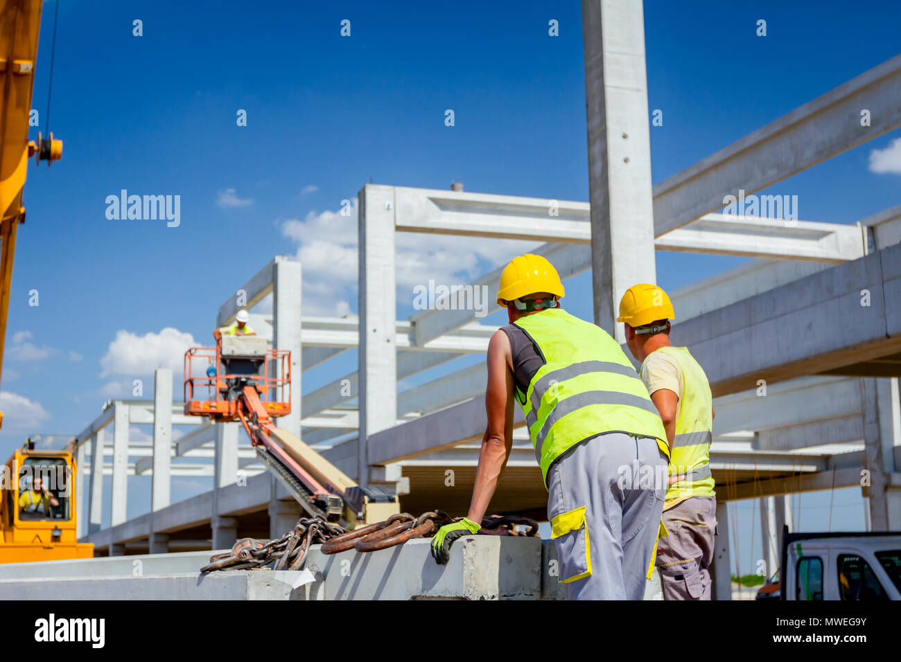 Unloading Hook Worker is preparing crane hook for unloading concrete joist from truck ...
