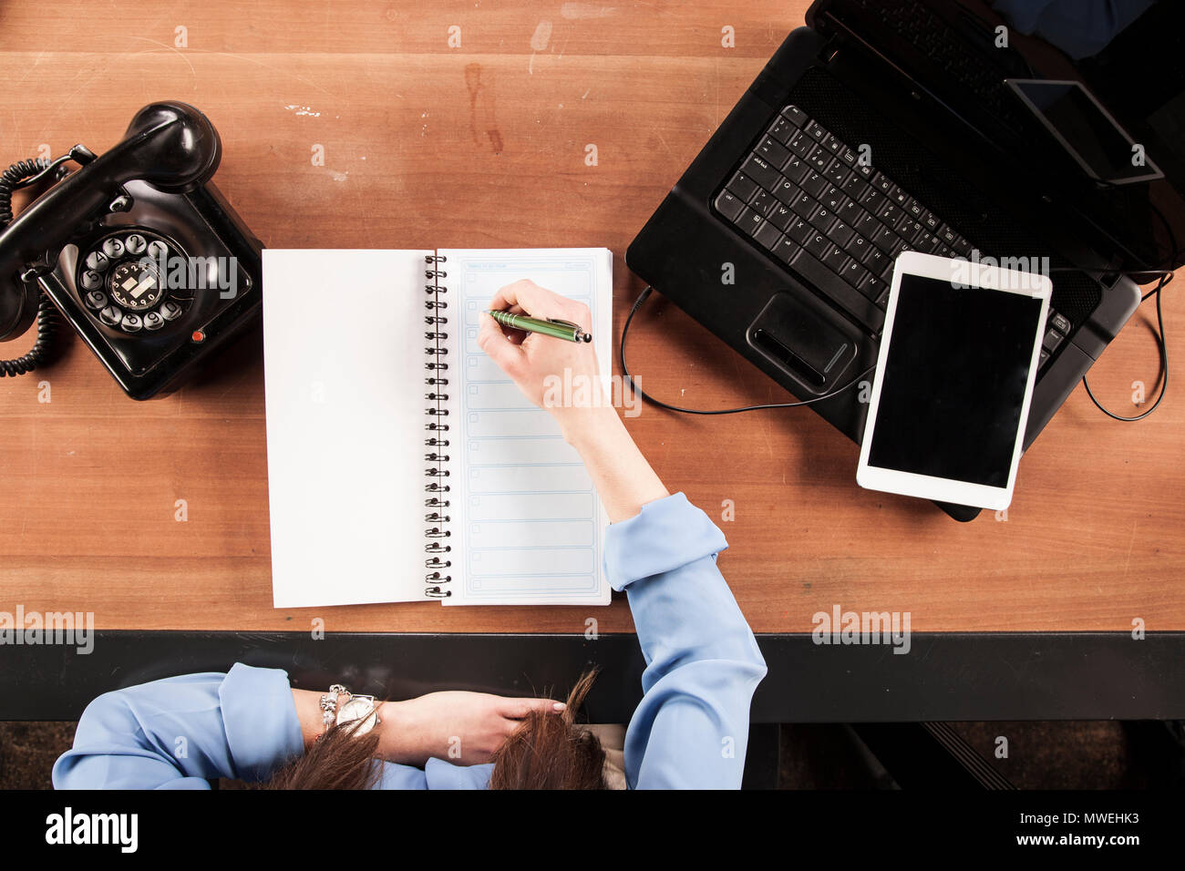 the secretary scrupulously makes calculations on paper, view from above Stock Photo