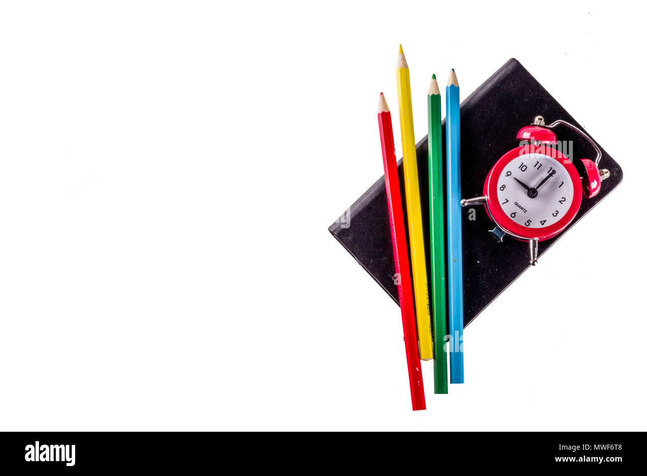 Back to school concept with books, alarm clock, color pencils, isolated