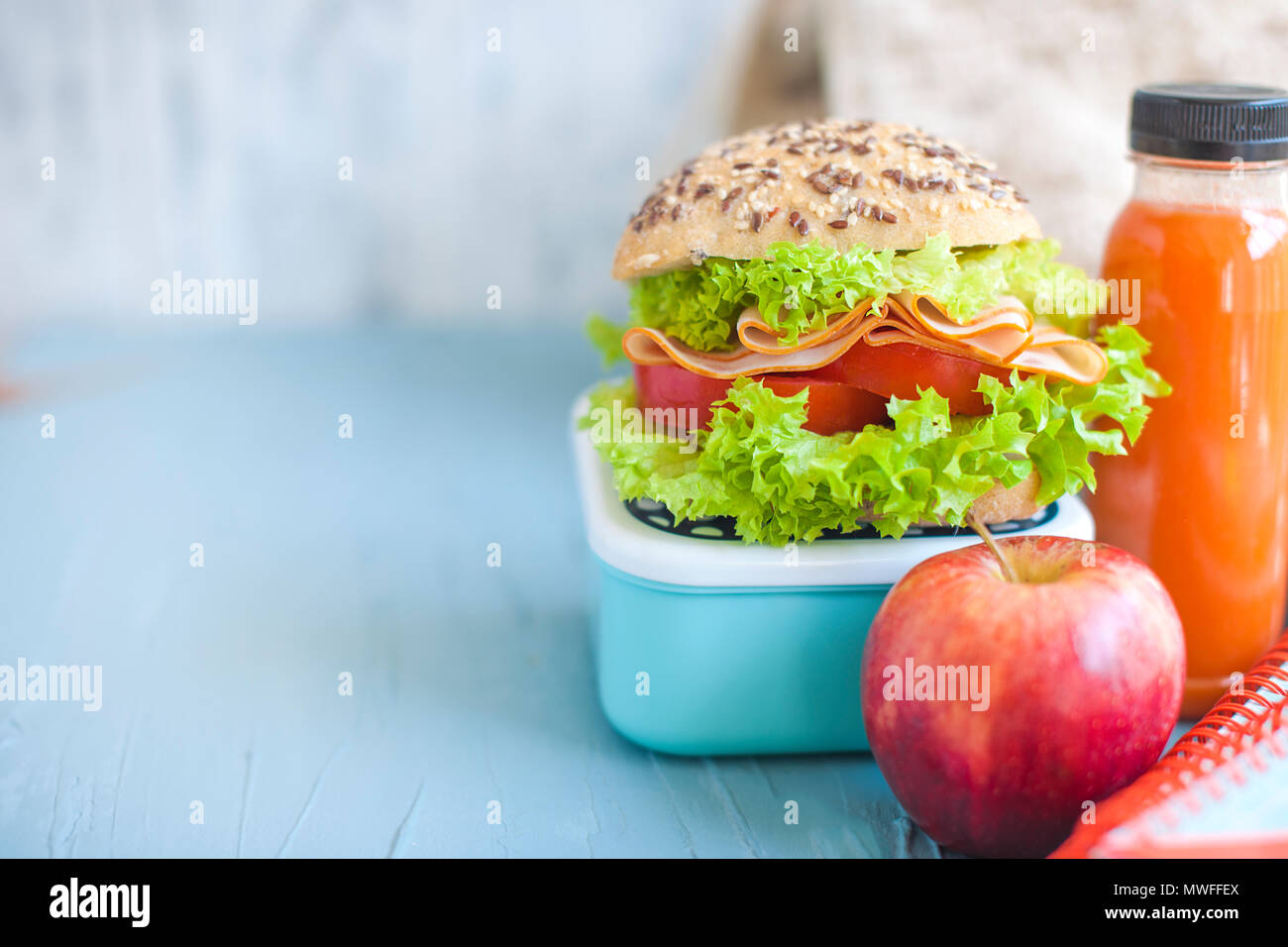 Sandwich for school lunch and juice, healthy lunch. School books on the