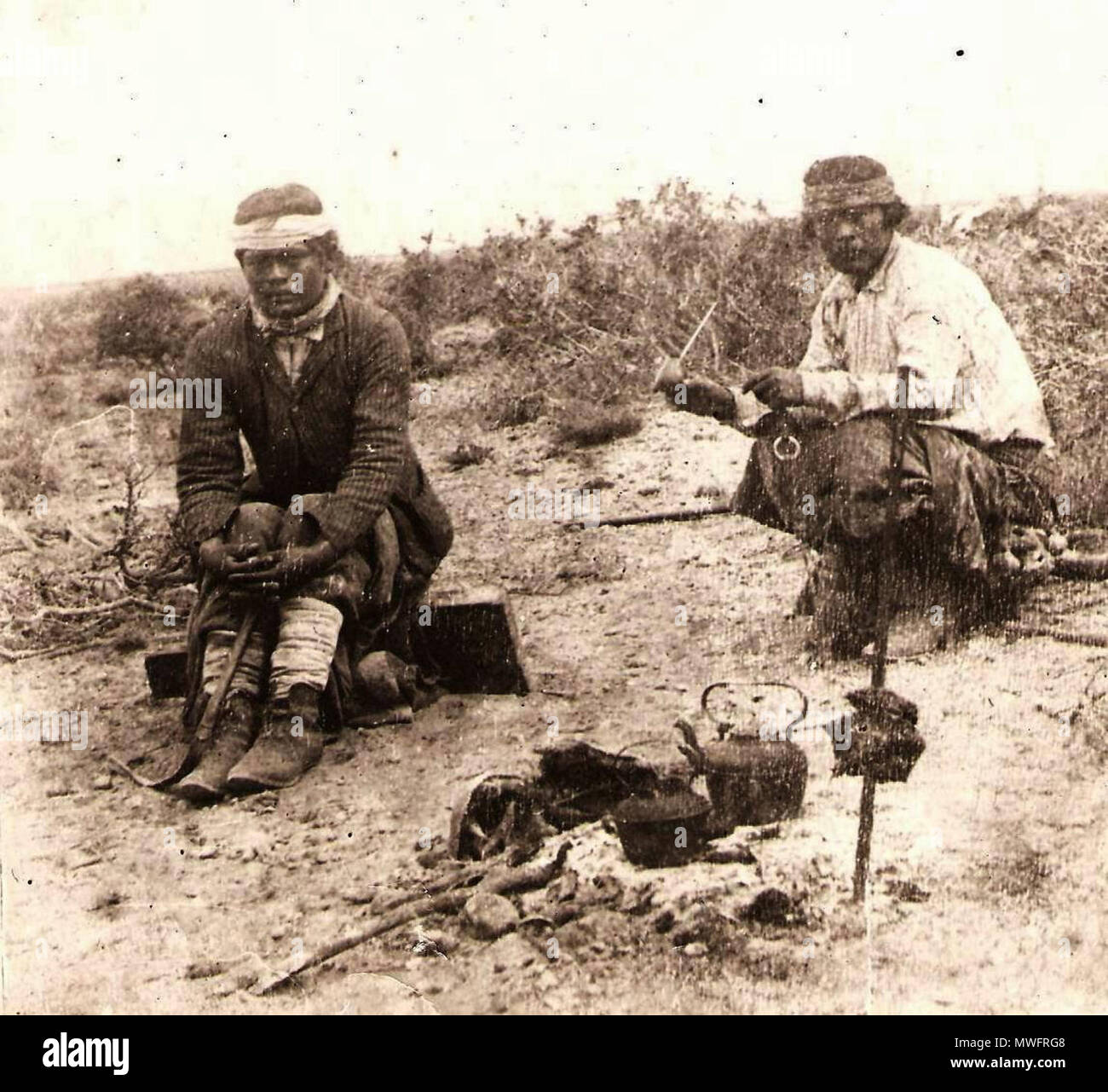 . Português: Mapuches tomando mate na Pampa enquanto se assa a carne no fogo c.1890. Documento Fotográfico. Inventario 303579 English: Mapuches drink mate in the Pampa (south american plain fields) while they make a barbecue. 26 July 2014, 23:58:06. Mapuches tomando mate en la pampa, mientras se cocina la carne al asador, c.1890. 394 Mapuches tomando mate na Pampa Stock Photo