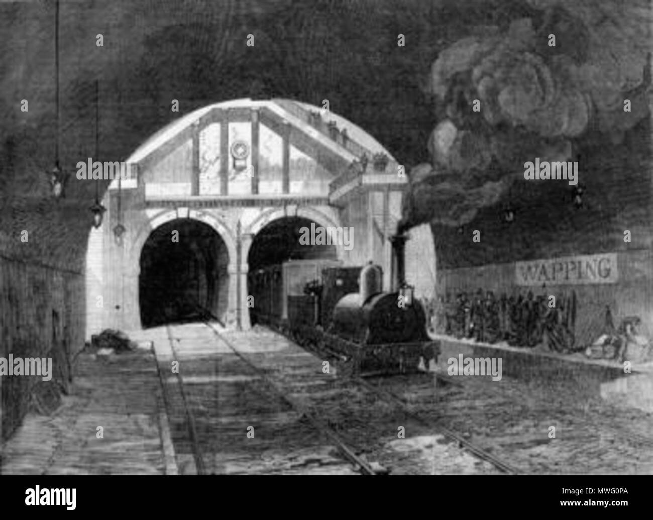 . English: Steam locomotive exiting the Thames Tunnel and arriving at what is now Wapping tube station, London . 8 January 1870. Unknown 591 Thames tunnel train Stock Photo