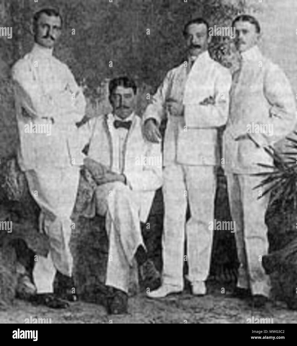 . English: Explorers and ethnographers Hiram M. Hiller, Jr. (far left), William H. Furness, III, and Alfred C. Harrison, Jr., along with Lewis Etzel, Furness' assistant. Sources appear to differ as to whether Furness or Etzel is seated. Photographed 1898 in Singapore. NOTE: The University of Pennsylvania Museum of Archaeology and Anthropology lists the figures as (left to right): Hiller, Etzel (seated), Furness, Harrison.[1] Français : Hiller (à gauche), Furness et Harrison, en compagnie de Lewis Etzel, l'assistant de Furness. Photographie prise à Singapour en1898 . 1898. Unknown 278 Hiller-Fu Stock Photo