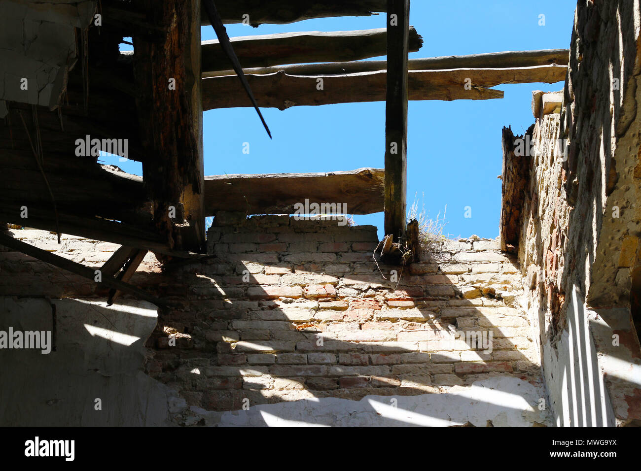 Destroyed ancient building. Collapsed ceiling in an old abandoned castle. Sunlight penetrating inside. Stock Photo