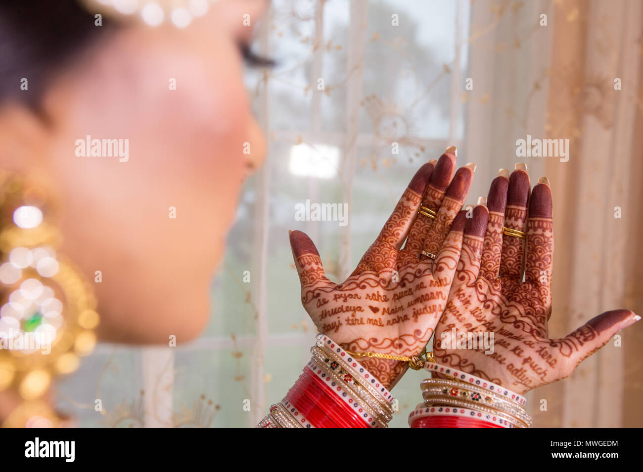 Pakistani & Indian bride wedding style showing Earring, Bangles & beautiful Mehndi design Stock Photo