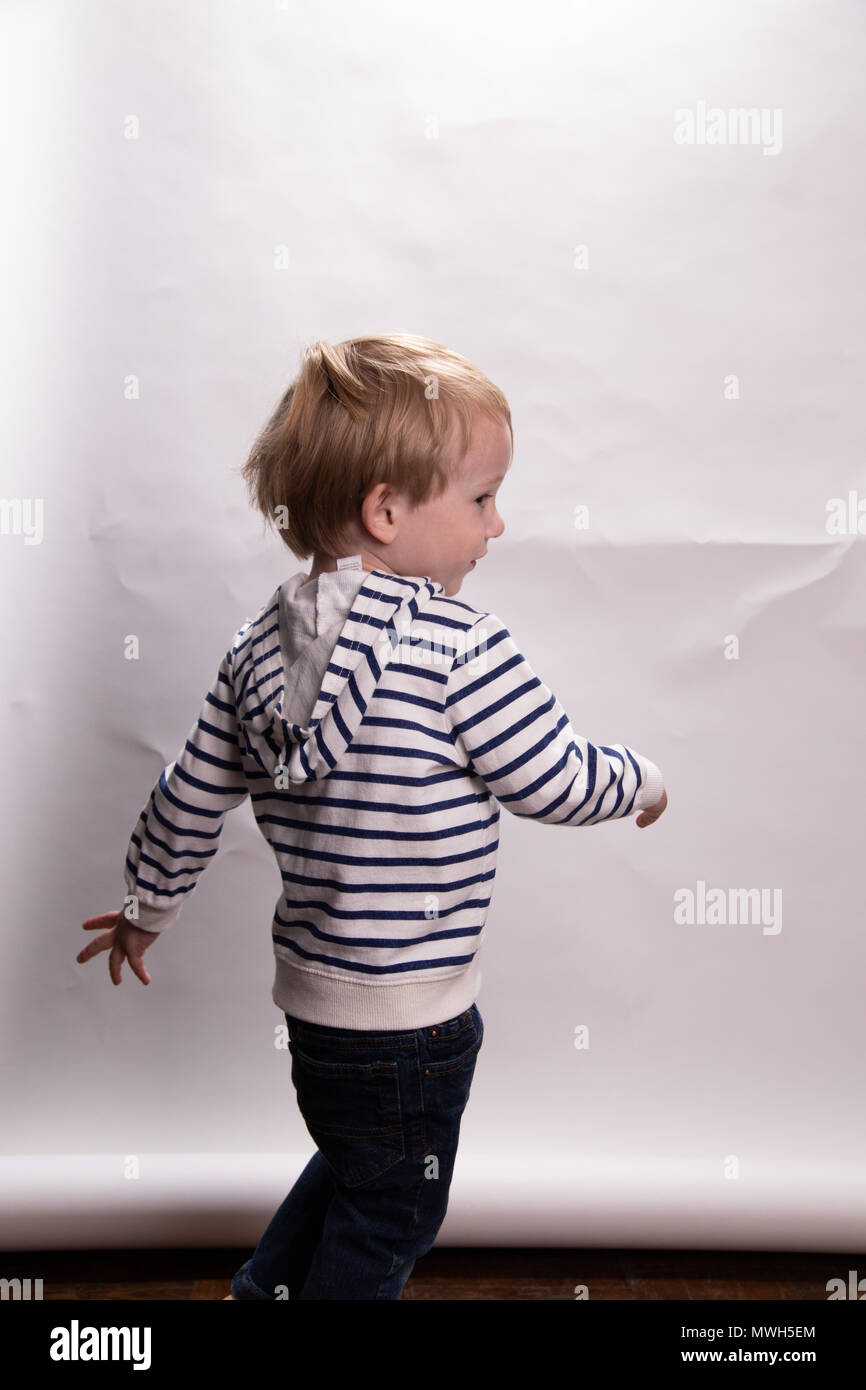 Young Caucasian Toddler Boy Acts Silly On A Photo Shoot In Front of A White Background Stock Photo