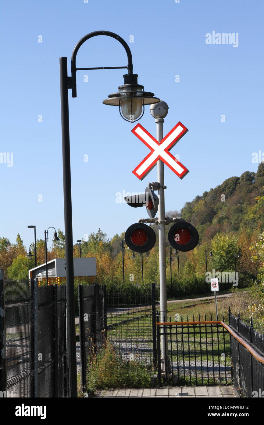 Artificial train crossing signal and lights with exterior decorative light fixture for pedestrians Stock Photo