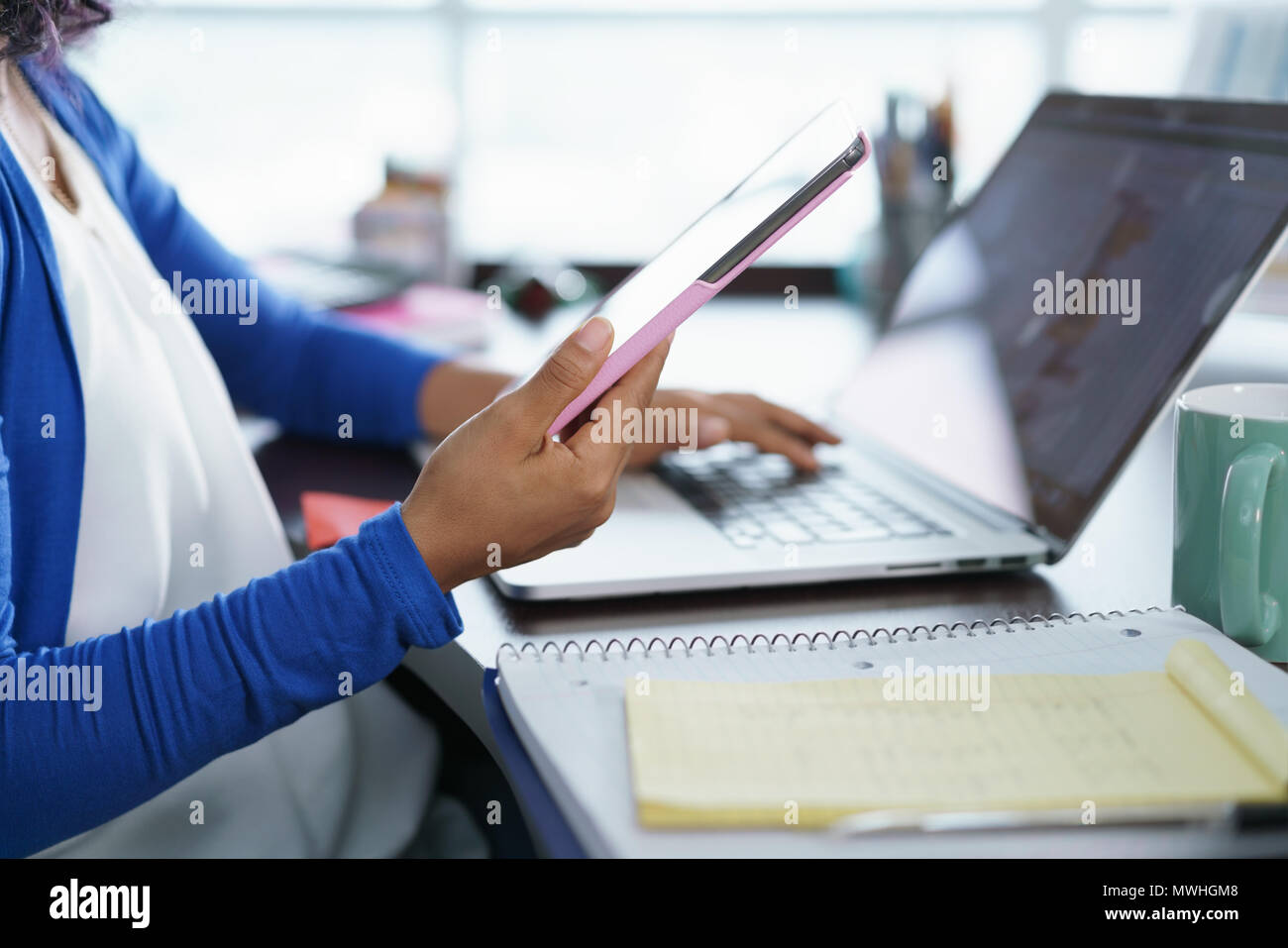 African american college student doing homework at home. Young black woman preparing school test with laptop computer and ipad digital tablet Stock Photo