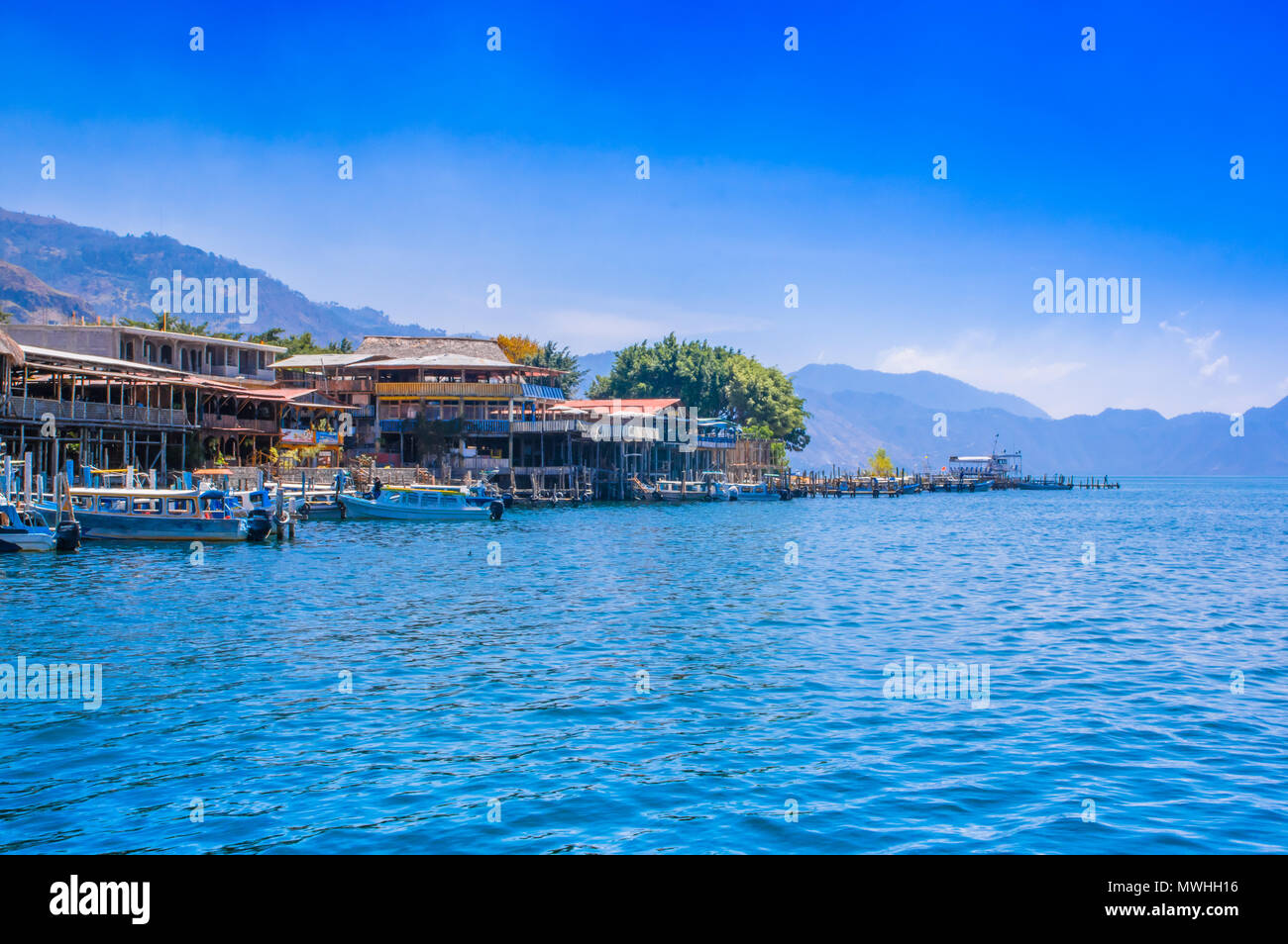Panajachel, Guatemala -April, 25, 2018: Outdoor view of boats on the shore, small village in the background on the shore, Atitlan lake Stock Photo