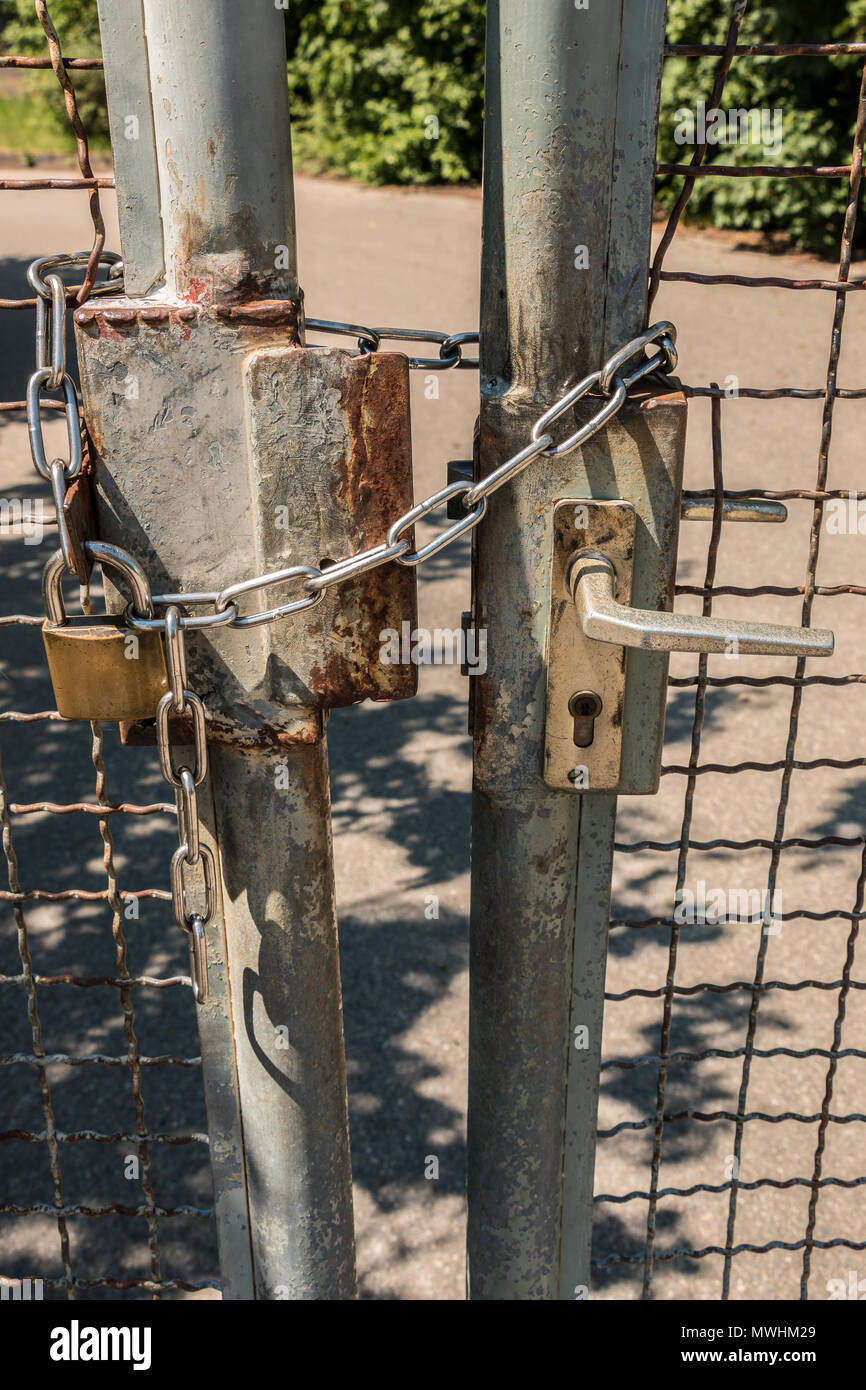 Closed gate with big steel chain and padlock Stock Photo