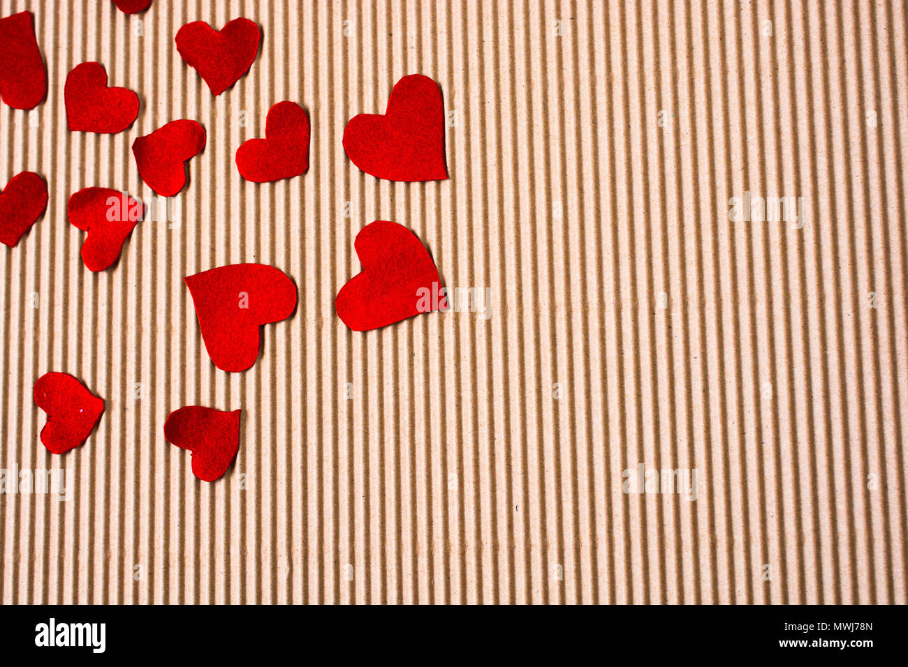 Red color paper hearts on a brown color cardboard Stock Photo Alamy