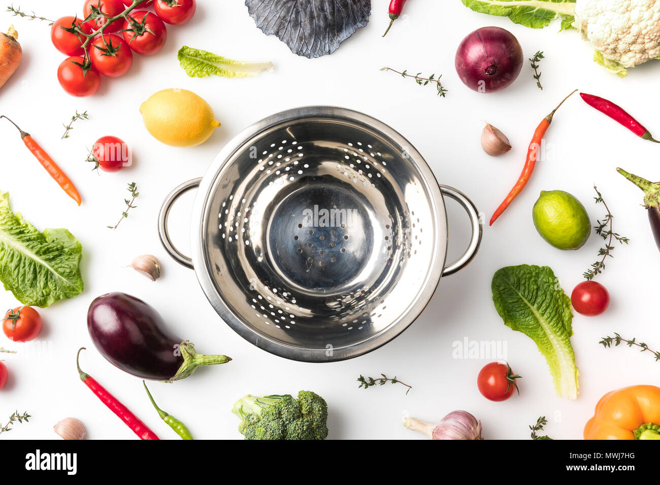 Top view of colander among uncooked vegetables isolated on white Stock ...