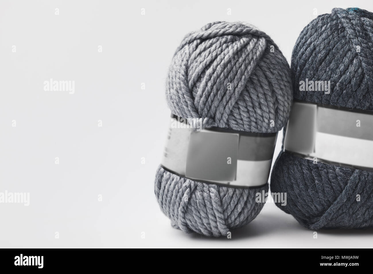 two grey yarn balls with blank tag isolated on white Stock Photo