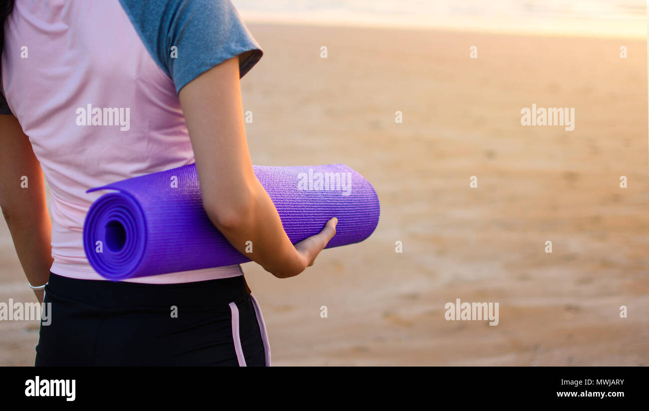 Girl with yoga mat on the beach for outdoors workout Stock Photo Alamy