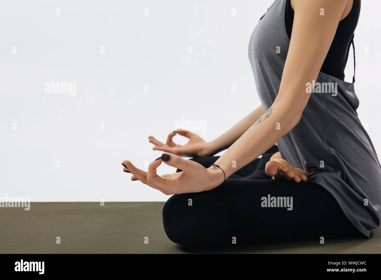 cropped image of woman meditating in yoga lotus pose isolated on white ...