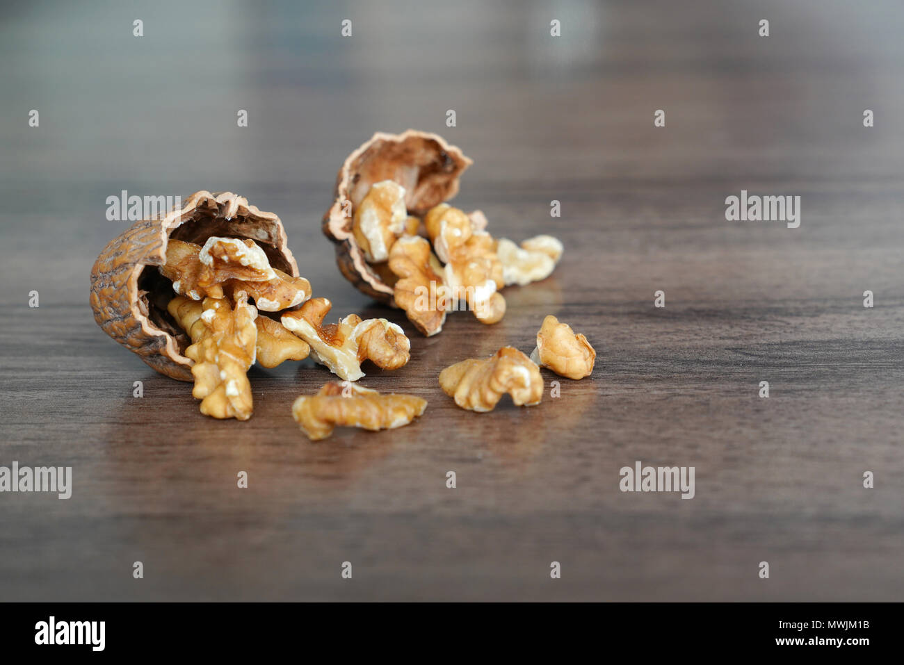 Kernel walnuts in nutshells on dark walnut table background Stock Photo