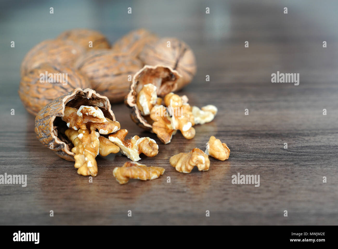 Kernel walnuts in nutshells with whole walnuts on dark walnut table background Stock Photo