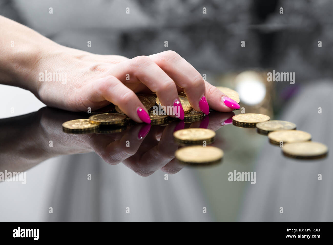Concept of enrichment and financial growth. Gold coins. Female working hard, saving money. Income Tax Raise. Feminine hand held over golden coins arra Stock Photo