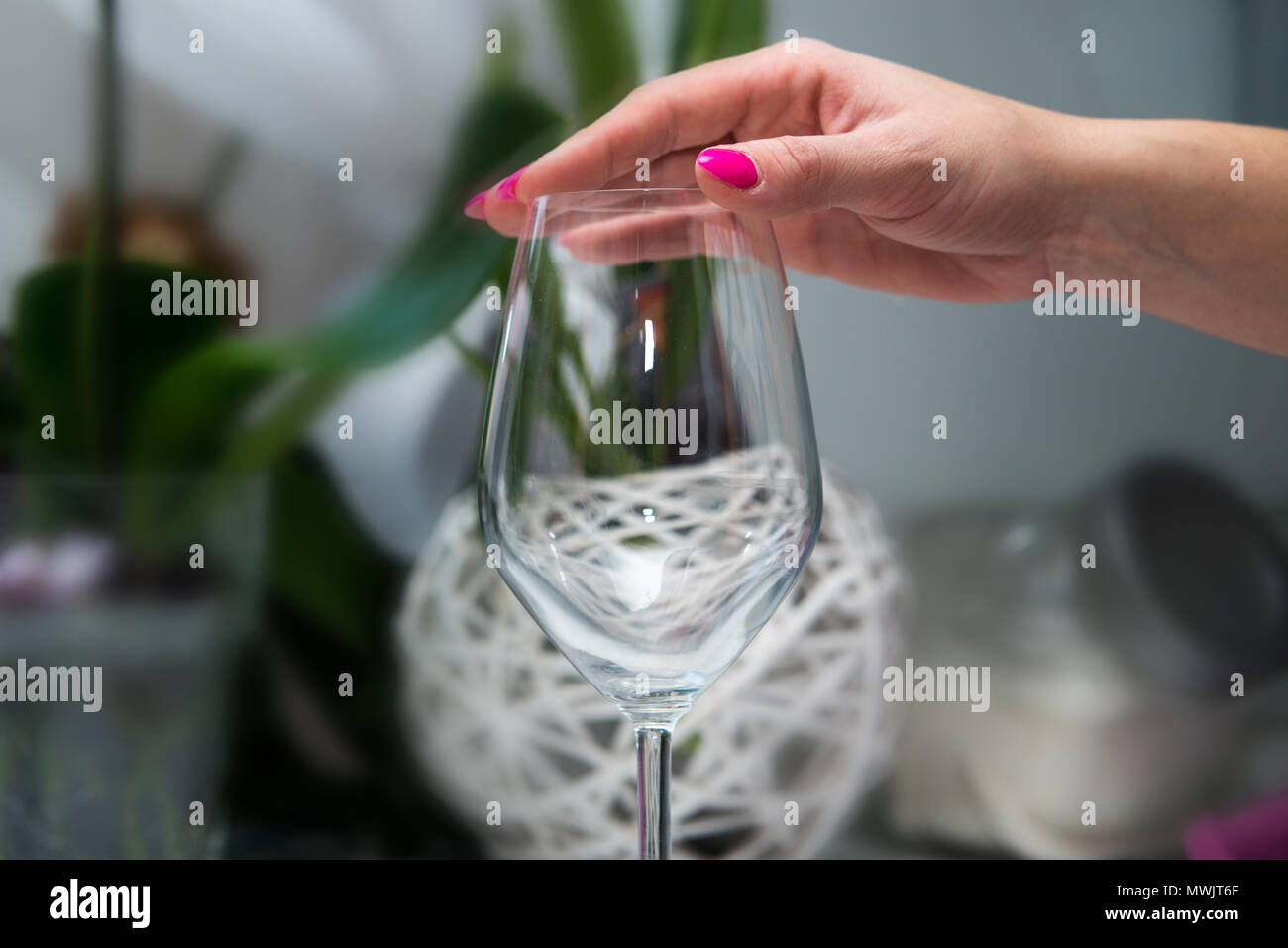 A woman is touching a glass of guilt. Longing for alcohol, for wine. Alcohol problems concept. Drinking wine, party, fun, loneliness, longing. Stock Photo