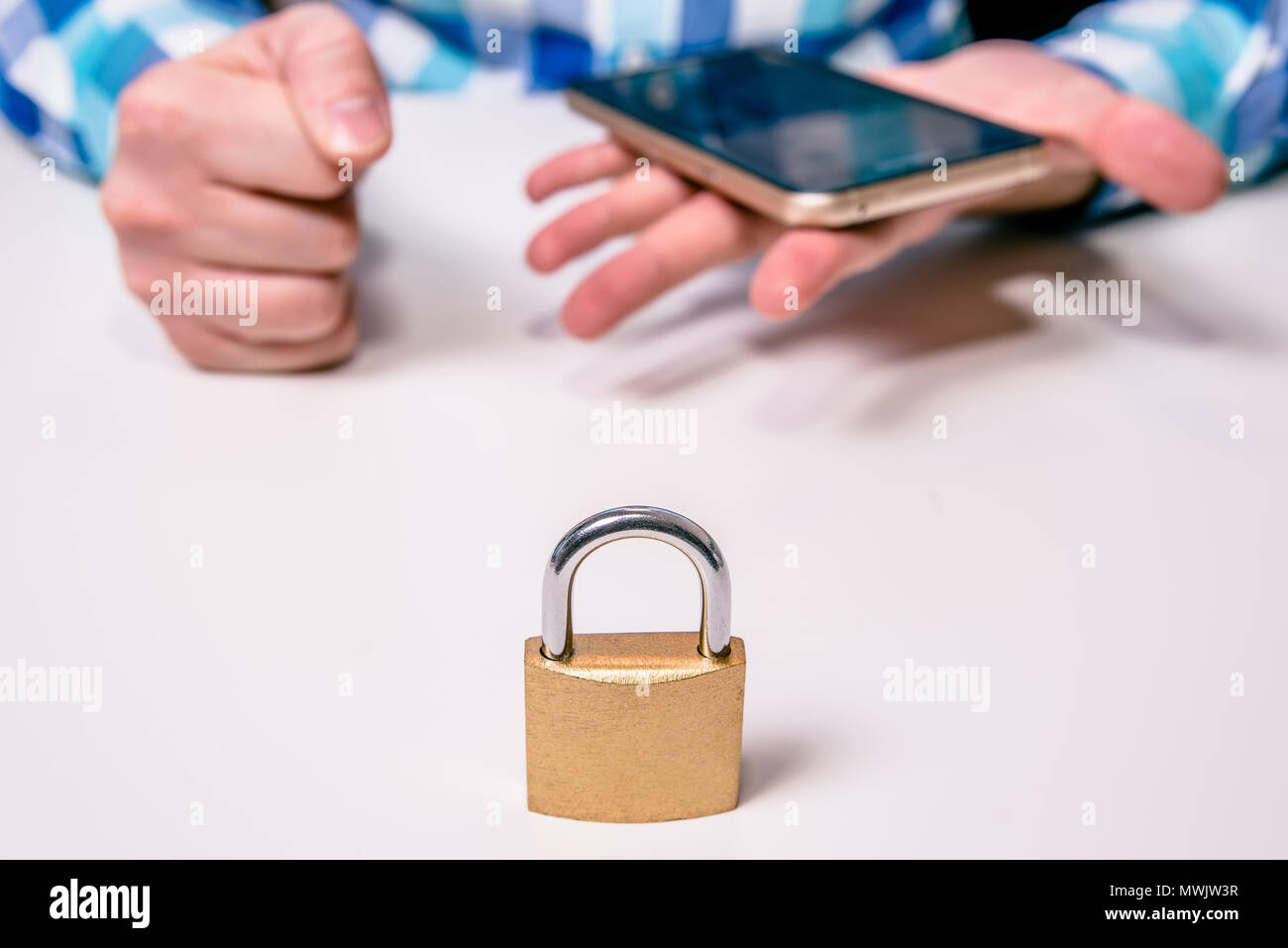 Locked padlock, in the background a man upset with a telephone. The ...