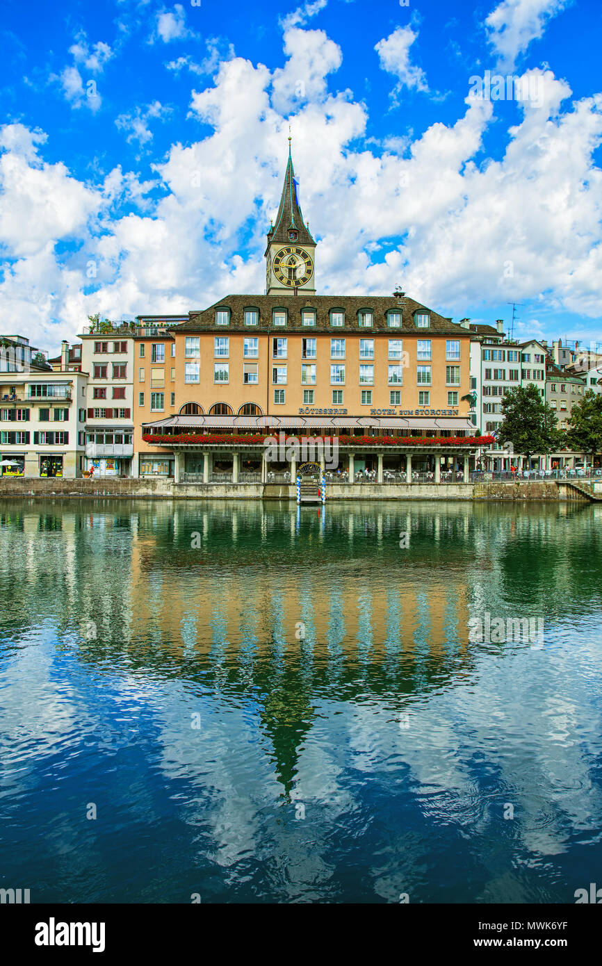 Zurich, Switzerland - July 30, 2016: buildings along the Limmat river in the historic part of the city of Zurich, St. Peter Church tower in the backgr Stock Photo