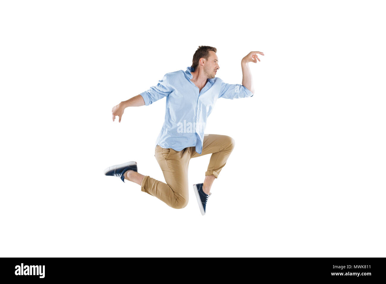 side view of young man jumping and looking away isolated on white Stock Photo