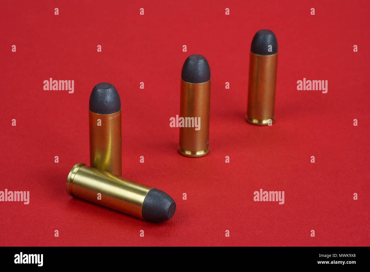 The .45 caliber revolver cartridges on red background Stock Photo - Alamy