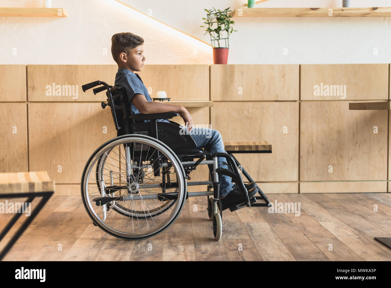 side view of little african-american boy in wheelchair Stock Photo