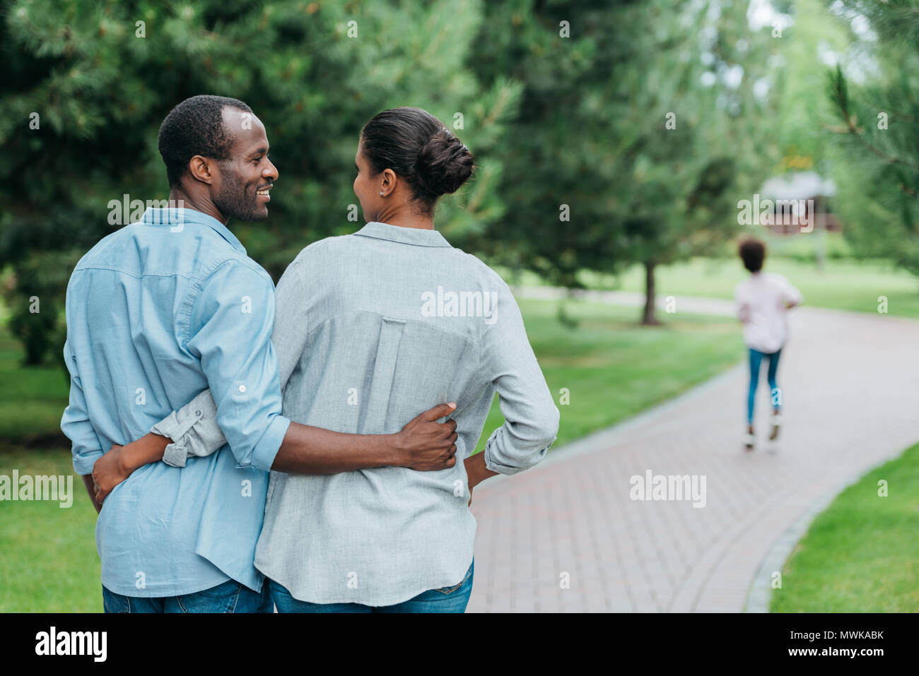 rear view of african american couple hugging and looking at each other ...