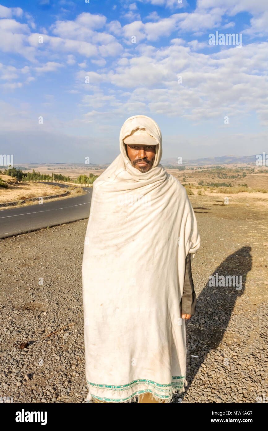 Debre Libanos, Ethiopia - February 17, 2015: Ethiopian man in traditionall dress is standing by the road number 3 near Debre Libanos in Ethiopia, Stock Photo