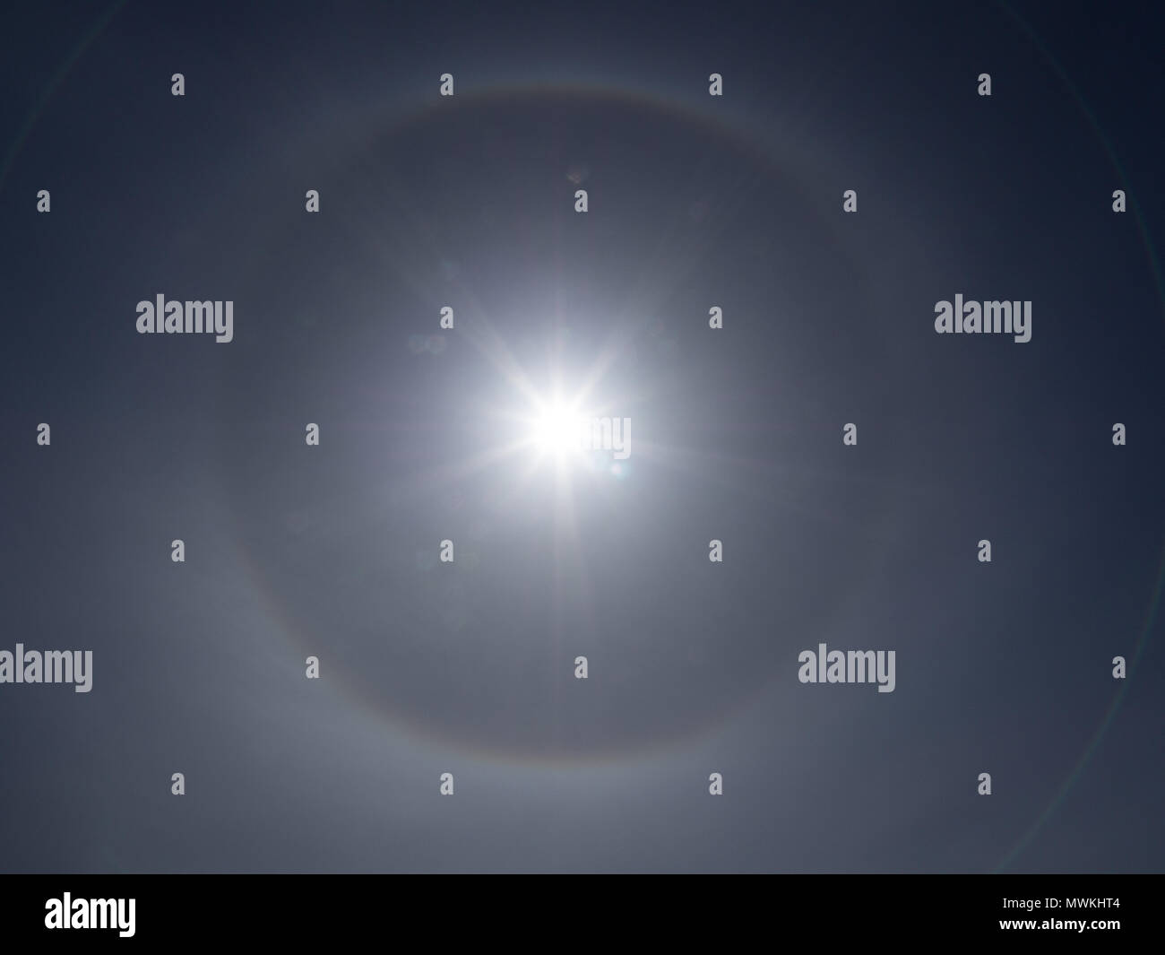Clear bright sun dog around the sun which is a 22 degree parhelia circle Stock Photo