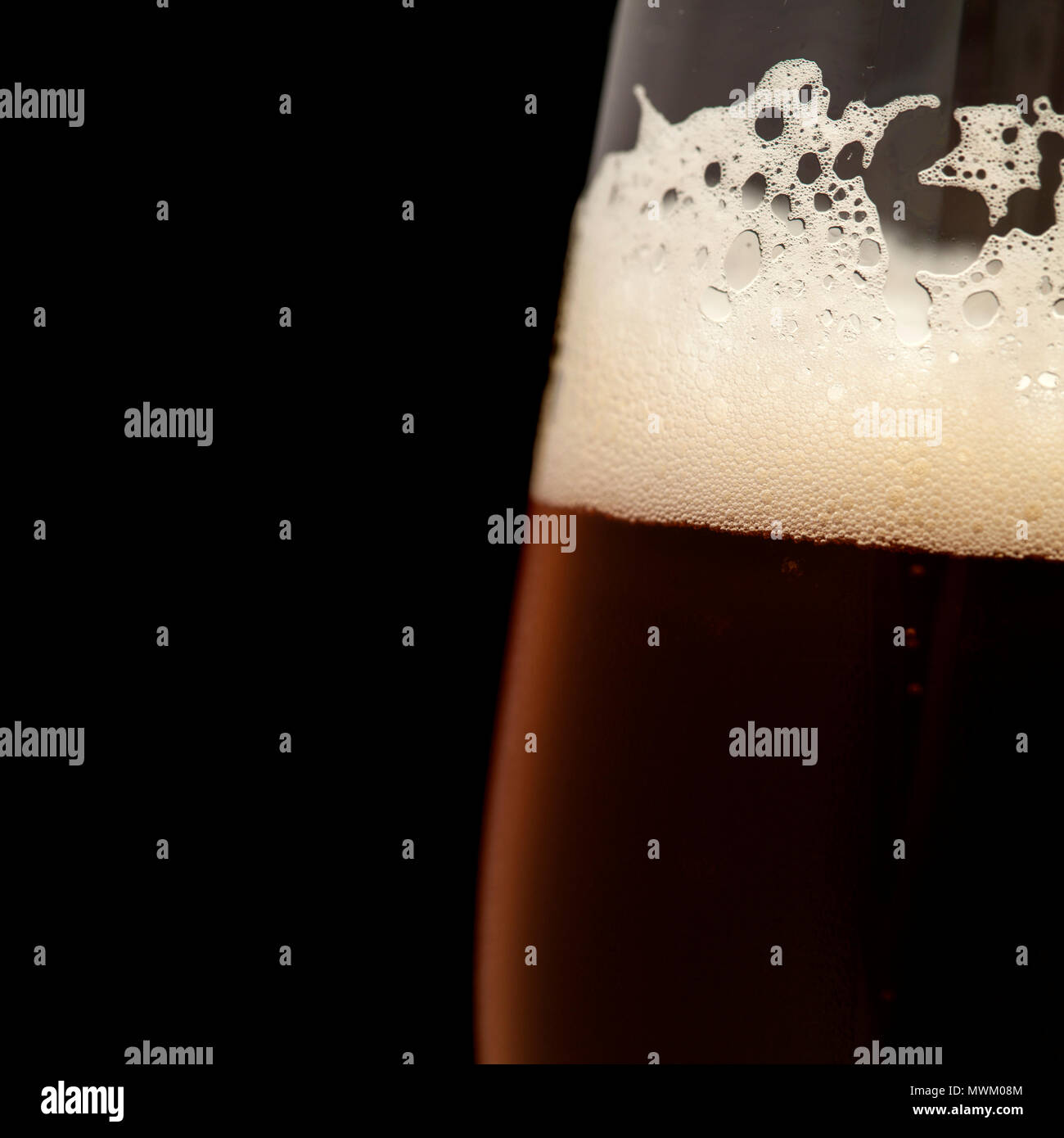 freshly poured dark beer in a taster glass, isolated on black Stock Photo